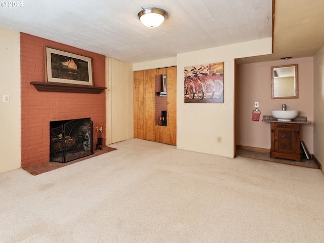 carpeted living area with a sink and a fireplace