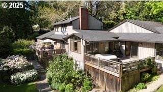 back of house with a wooden deck, a chimney, and stairway