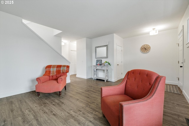 living area featuring baseboards, wood finished floors, and stairs