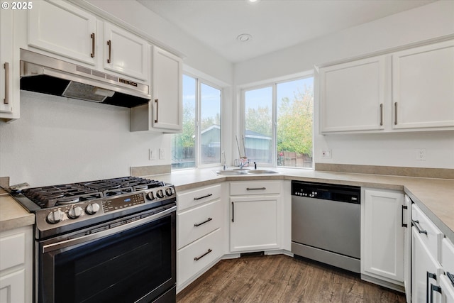 kitchen with a sink, light countertops, appliances with stainless steel finishes, under cabinet range hood, and white cabinetry