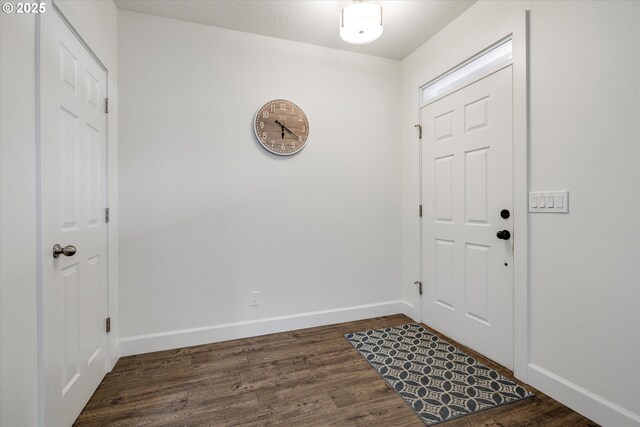 foyer entrance featuring dark wood-style floors and baseboards