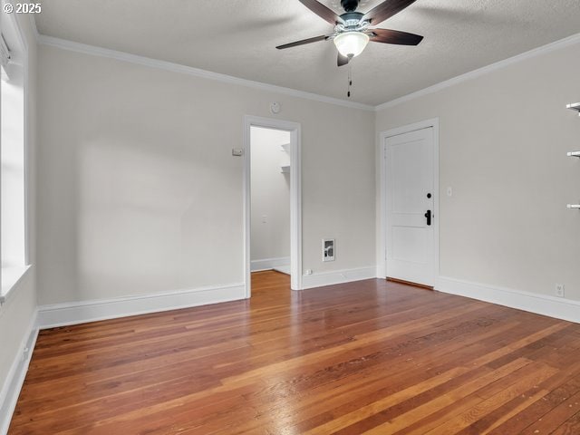 unfurnished room featuring hardwood / wood-style floors, ornamental molding, ceiling fan, a textured ceiling, and baseboards