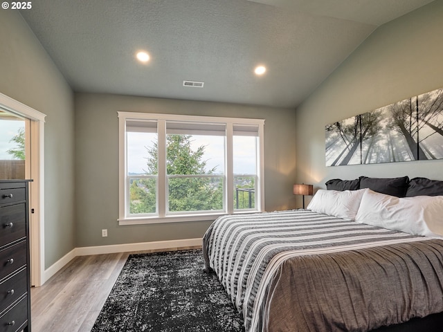 2231 SE Genesis Ct, Salem, OR 97306 - bedroom featuring multiple windows, vaulted ceiling, recessed lighting, wood finished floors, and baseboards