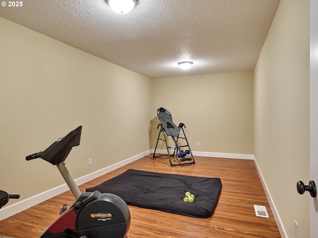 2231 SE Genesis Ct, Salem, OR 97306 - workout room with a textured ceiling, wood finished floors, and baseboards