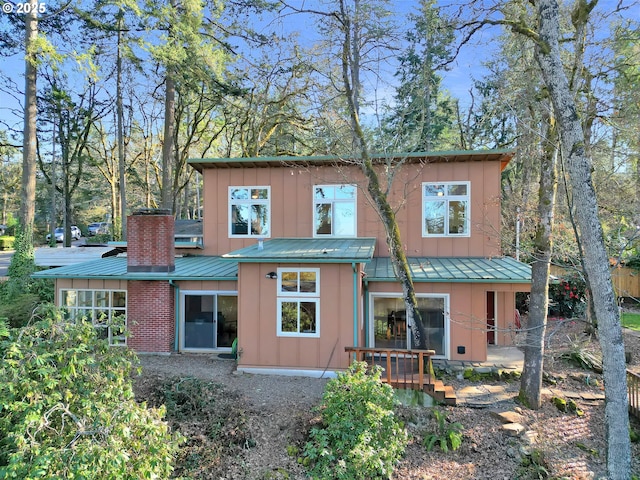 rear view of property with a standing seam roof, board and batten siding, and metal roof