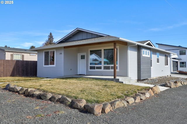 view of front of home with fence, a front lawn, and board and batten siding