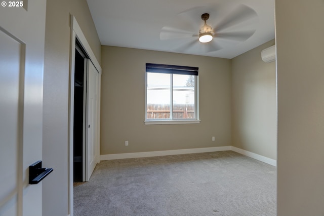 unfurnished bedroom with light carpet, baseboards, ceiling fan, an AC wall unit, and a closet