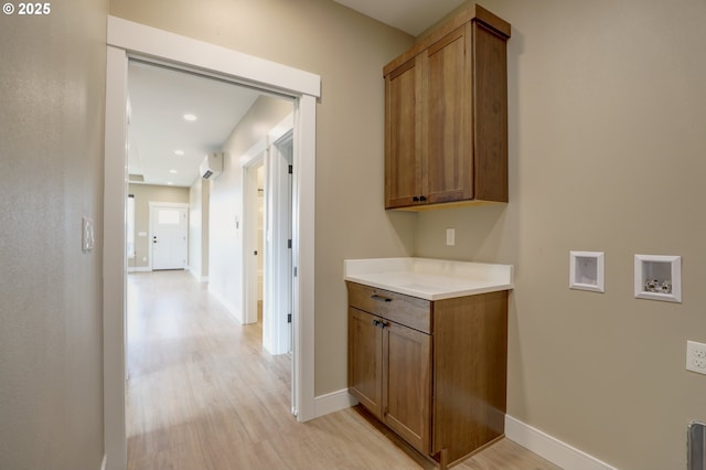 hallway with light wood finished floors, recessed lighting, baseboards, and a wall mounted air conditioner