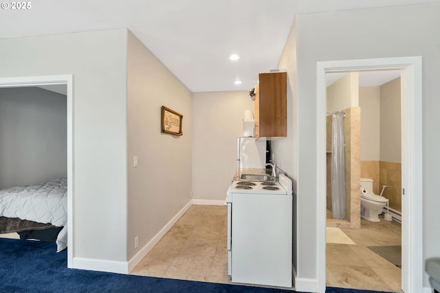 washroom featuring sink, tile walls, and baseboard heating