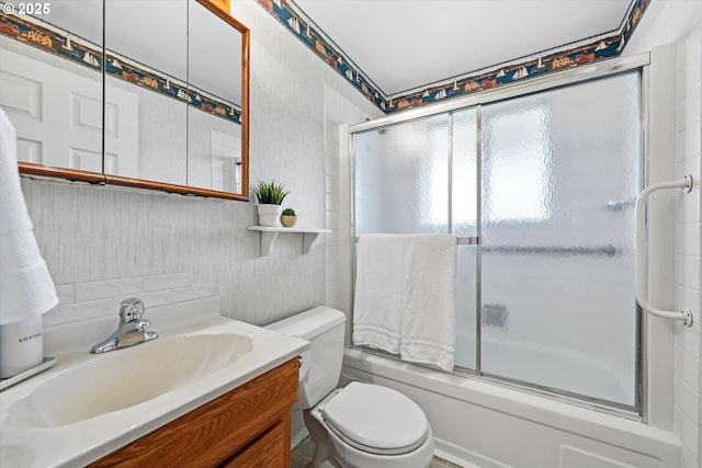 full bathroom with enclosed tub / shower combo, vanity, and toilet