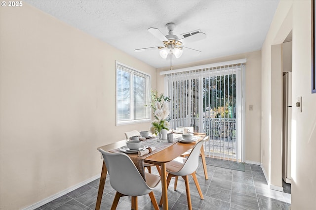 dining space with ceiling fan and a textured ceiling