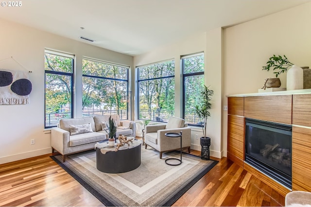 2172 NW 16th Ave, Portland, OR 97209 - living room featuring a glass covered fireplace, baseboards, and wood finished floors