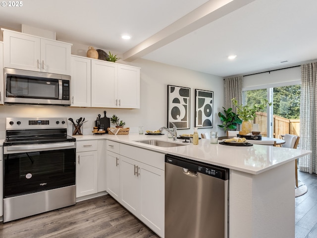 10386 NE 46th St, Vancouver, WA 98682 - kitchen with stainless steel appliances, a sink, a peninsula, light countertops, and light wood-style floors