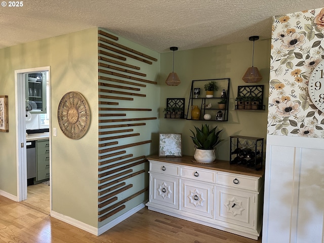 hallway with a textured ceiling and light wood-style floors