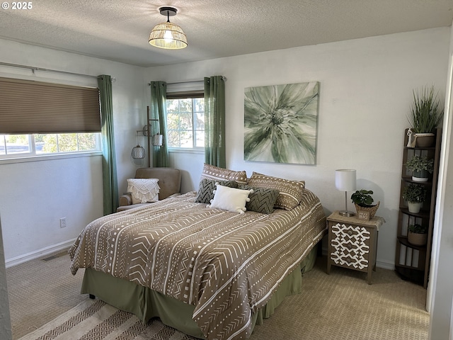 carpeted bedroom with visible vents, a textured ceiling, and baseboards