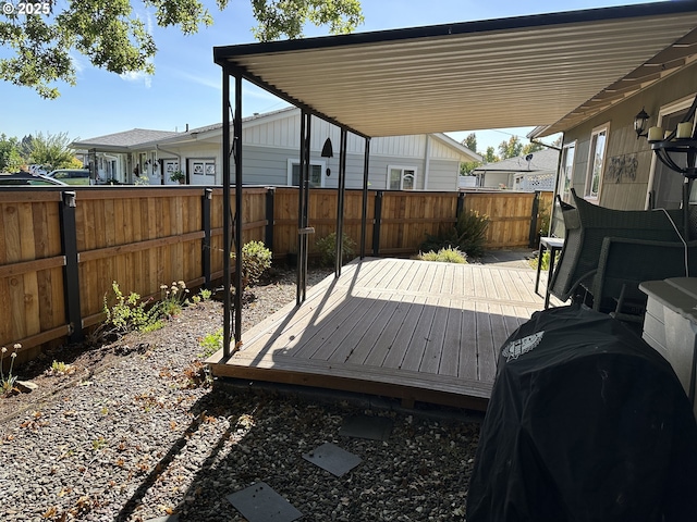 wooden deck with a fenced backyard and grilling area