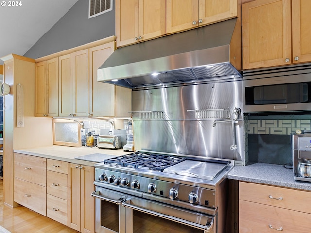 kitchen with appliances with stainless steel finishes, light brown cabinets, visible vents, and under cabinet range hood