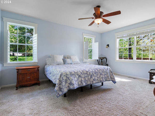 bedroom with multiple windows, carpet flooring, visible vents, and baseboards