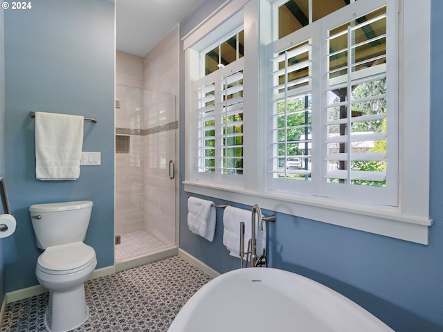 full bathroom with a healthy amount of sunlight, a shower stall, toilet, and a freestanding bath