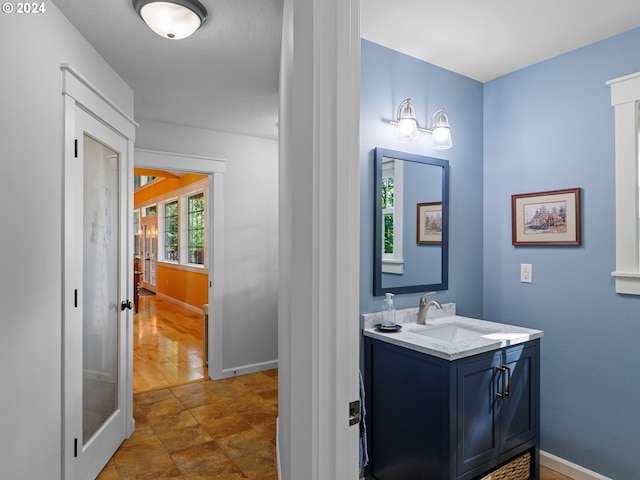 bathroom with french doors, vanity, and baseboards