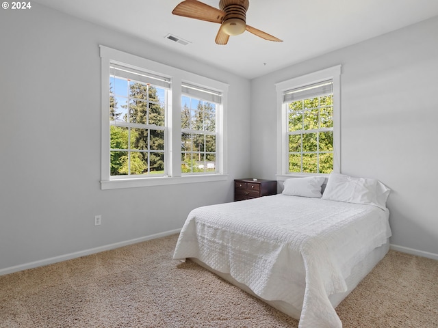 carpeted bedroom featuring visible vents, ceiling fan, and baseboards