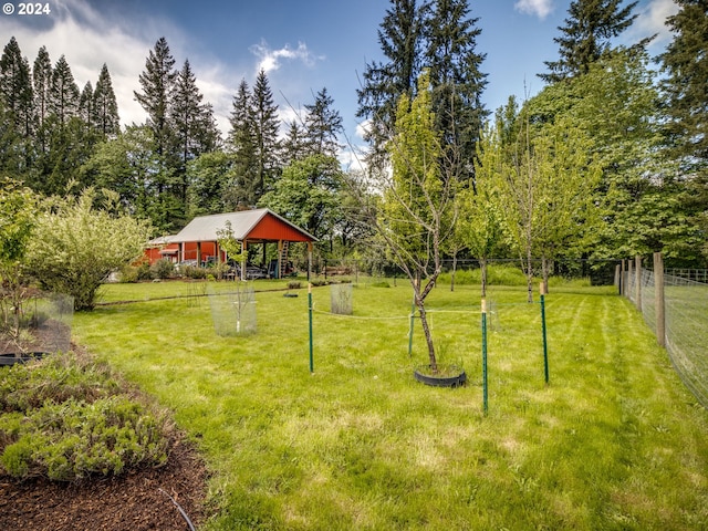 view of yard with fence and an outbuilding