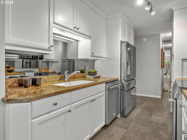 kitchen with stainless steel appliances, a sink, light stone countertops, and white cabinets