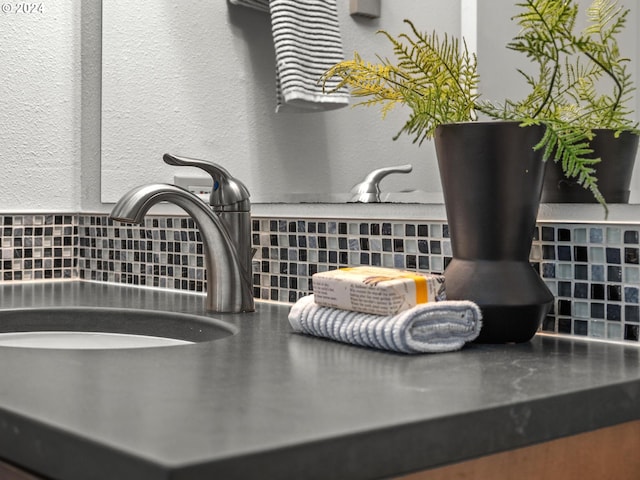 interior details with a textured wall, a sink, and a wood stove