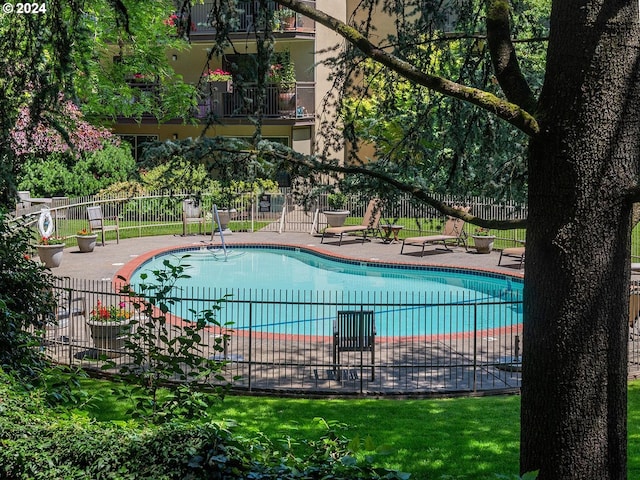 pool with a patio area and fence