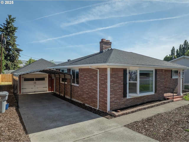 1911 E 12th St, The Dalles, OR 97058 - view of side of home with driveway, a chimney, a shingled roof, and brick siding