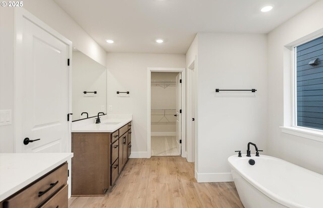 8710 S 3rd St, Ridgefield, WA 98642 - full bath featuring vanity, a soaking tub, recessed lighting, a walk in closet, and wood finished floors