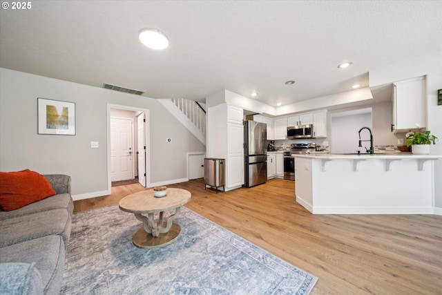 1686 NE 27th Ter, Gresham, OR 97030 - living room featuring stairs, light wood finished floors, and recessed lighting