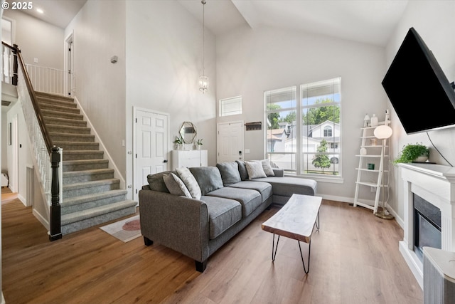 1686 NE 27th Ter, Gresham, OR 97030 - living room featuring high vaulted ceiling, wood finished floors, stairway, and a glass covered fireplace