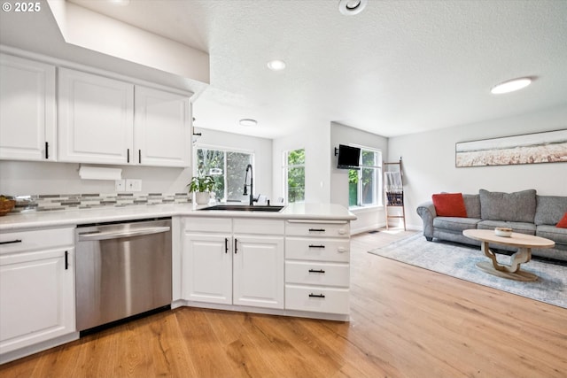 1686 NE 27th Ter, Gresham, OR 97030 - kitchen featuring dishwasher, open floor plan, a peninsula, light wood-style flooring, and white cabinetry