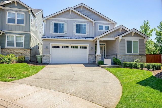 craftsman-style home featuring a garage, a front yard, stone siding, board and batten siding, and concrete driveway