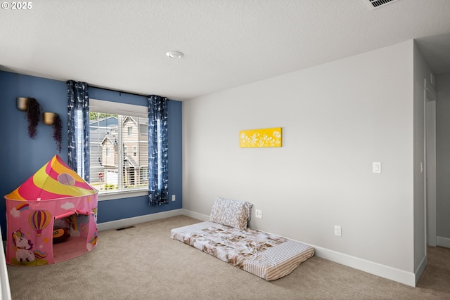 playroom featuring carpet floors, a textured ceiling, baseboards, and visible vents