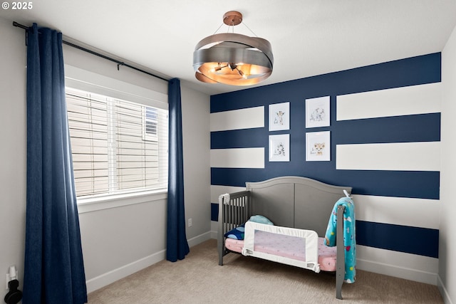 bedroom featuring baseboards, carpet flooring, and a nursery area