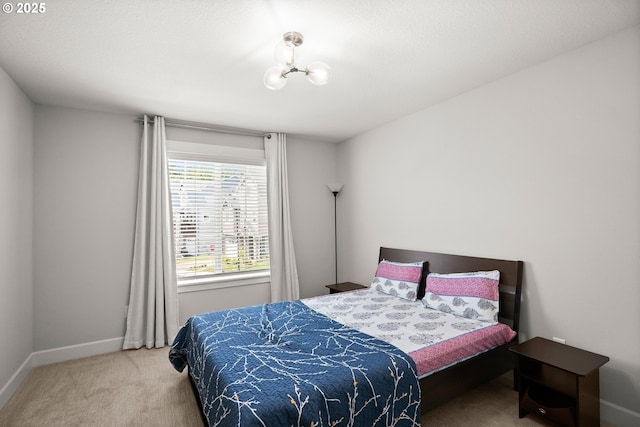 bedroom featuring carpet floors, baseboards, and a chandelier