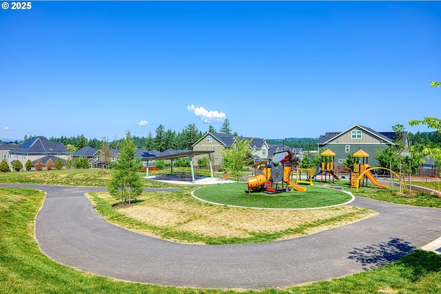 community jungle gym featuring a lawn and a residential view