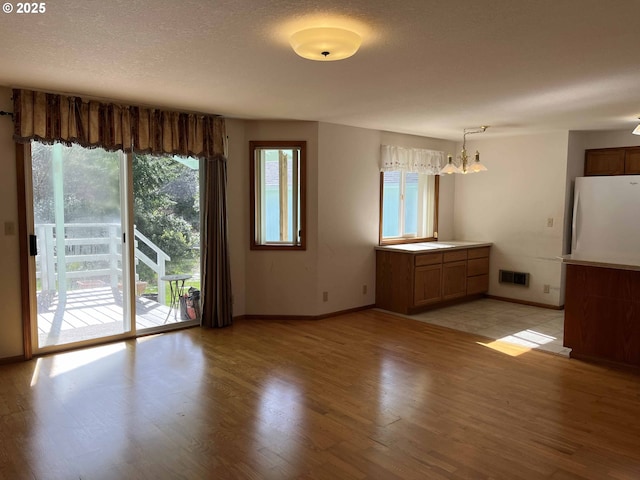 4040 Munsel Creek Dr, Florence, OR 97439 - interior space featuring light wood-type flooring, visible vents, a textured ceiling, and baseboards