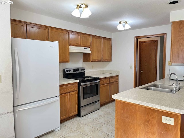 4040 Munsel Creek Dr, Florence, OR 97439 - kitchen featuring electric stove, brown cabinets, freestanding refrigerator, under cabinet range hood, and a sink