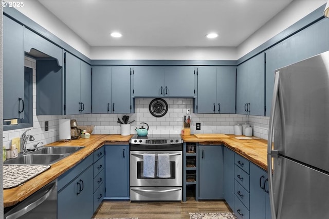106 Green Valley Rd, Oakland, OR 97462 - kitchen featuring appliances with stainless steel finishes, blue cabinets, butcher block countertops, and wood finished floors