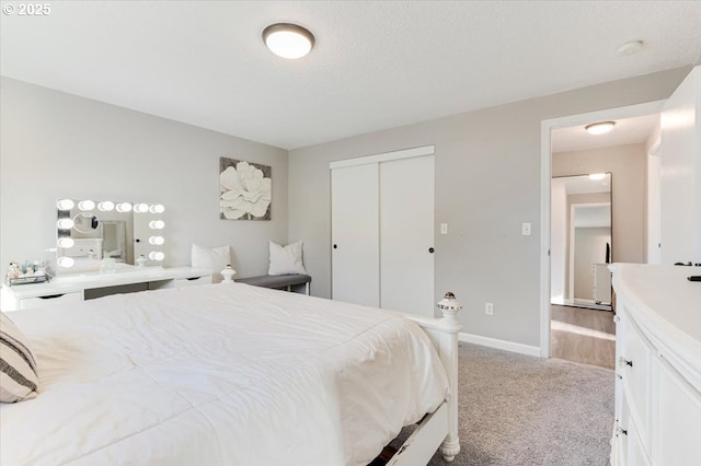 bedroom featuring light carpet, a closet, and a textured ceiling