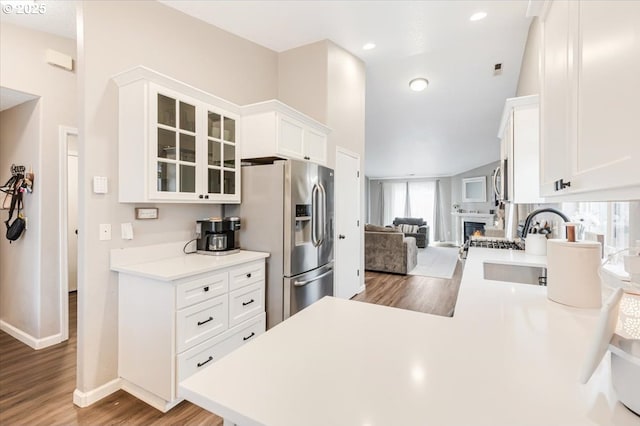 kitchen featuring hardwood / wood-style flooring, sink, stainless steel fridge with ice dispenser, and white cabinets