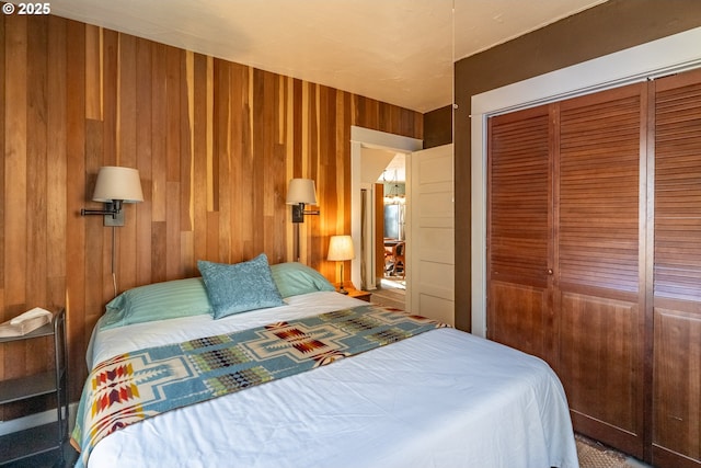 bedroom with wood walls and a closet