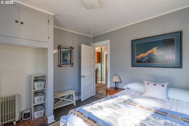 bedroom with radiator, attic access, ornamental molding, and baseboards