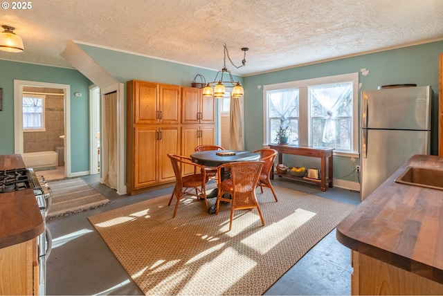 dining space featuring a textured ceiling, baseboards, and a notable chandelier