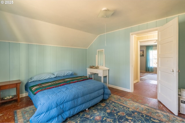 bedroom with vaulted ceiling and wood finished floors