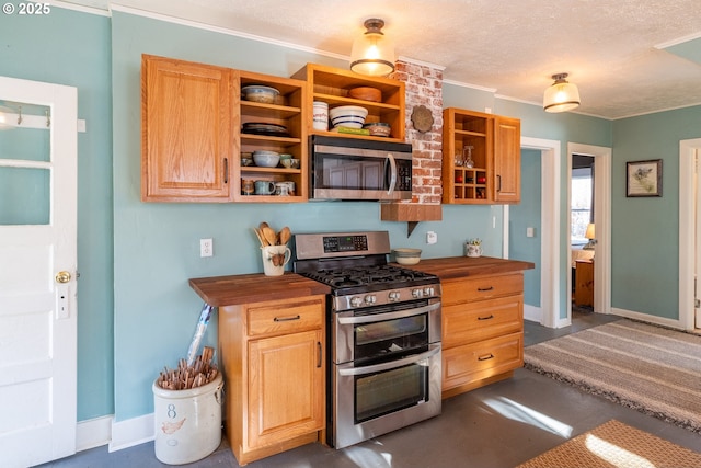 kitchen featuring crown molding, open shelves, stainless steel appliances, butcher block counters, and a textured ceiling