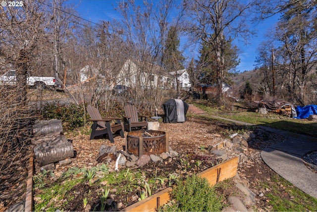 view of yard with a garden and an outdoor fire pit